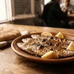 A plate of freshly grilled sardines served with Moroccan spices and a side of traditional bread, a Tangier specialty