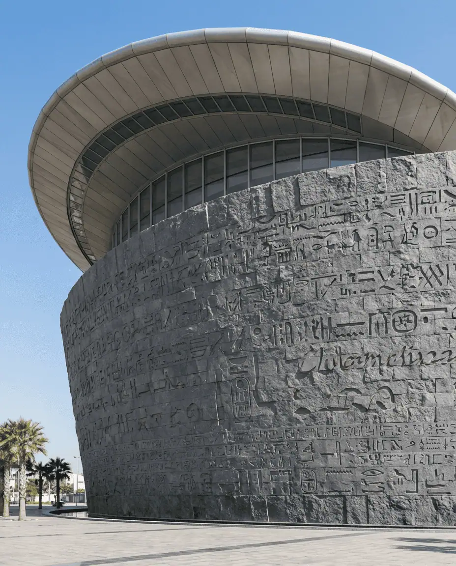 A striking architectural shot of the Bibliotheca Alexandrina's tilted roof and granite walls carved with characters from 120 different scripts.