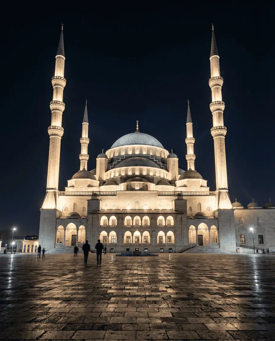 A majestic night shot of the Kocatepe Mosque, with its four minarets and central dome brilliantly illuminated against the dark sky.